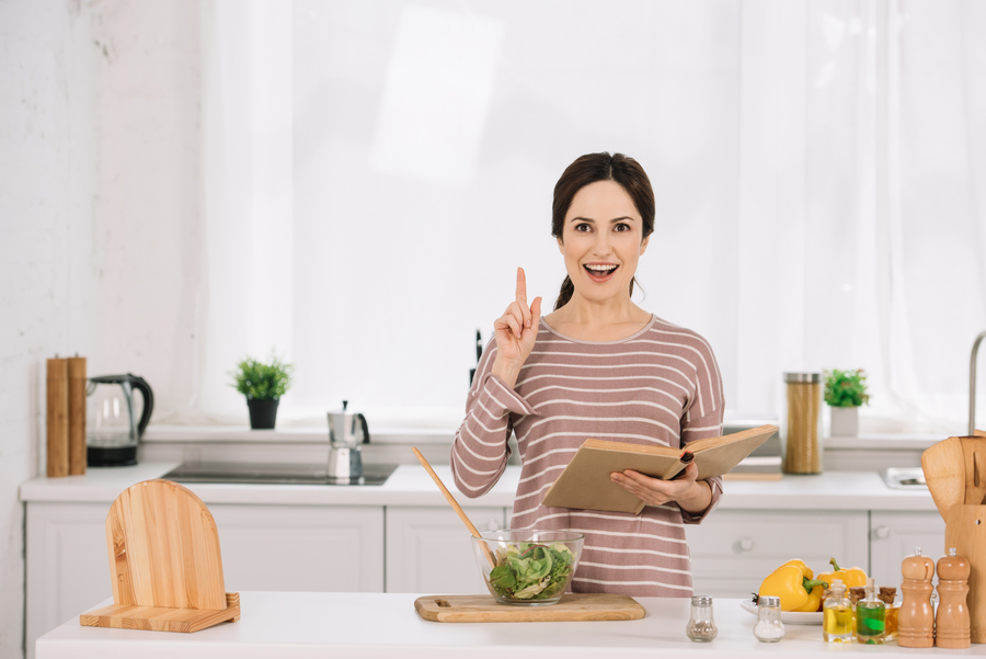 Mulher na cozinha tendo ideias de receitas da xepa